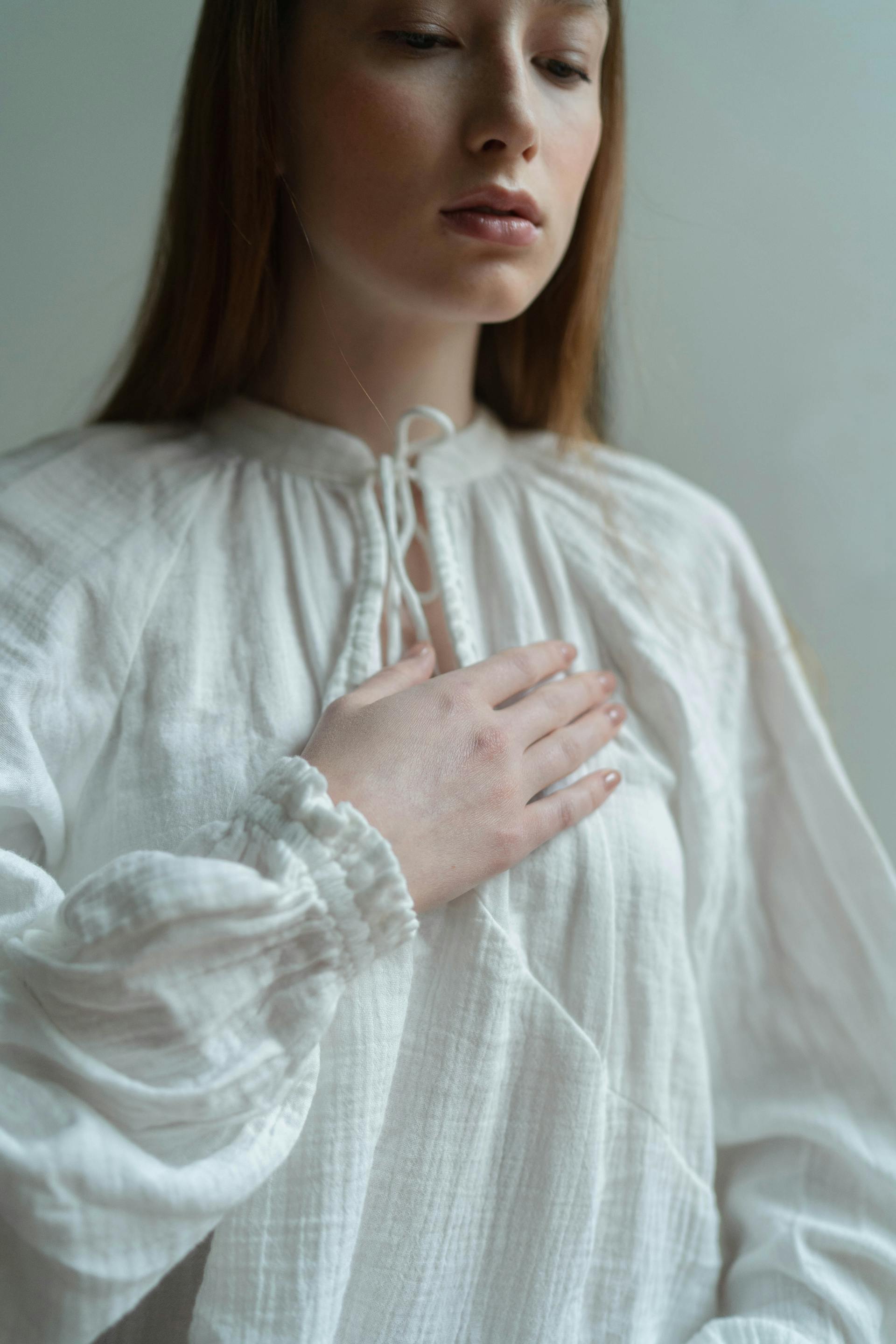 Woman in contemplative pose demonstrating body awareness and mind-body connection in therapy